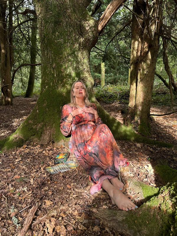 Heather in the woods leaning on a tree